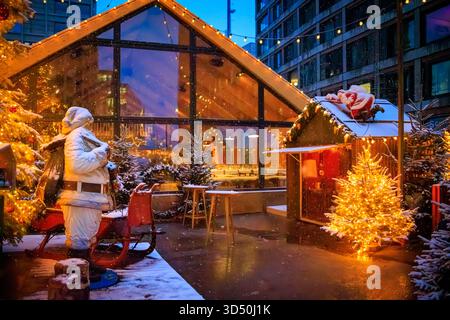 Zauberhafte Szene auf dem Zürcher Weihnachtsmarkt mit Weihnachtsmann, Weihnachtsbaum und funkelnden Lichtern und Schneefall schaffen ein Winterwunderland in der Schweiz Stockfoto