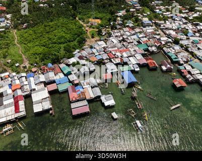 Stelzenhäuser mit bunten Dächern und kleinen Booten, die am Ufer verankert sind. Siargao, Philippinen. Stockfoto