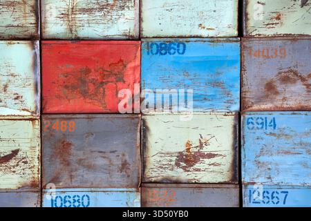 Stapel von nummerierten rostigen und lackierten Stahlkästen für Kartoffeln in blauen und roten Farben, die ein ordentliches Raster-abstrakt bilden Stockfoto