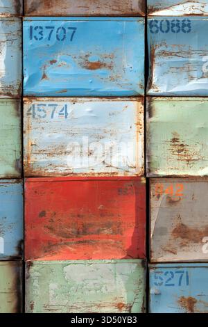 Stapel von nummerierten rostigen und lackierten Stahlkästen für Kartoffeln in blauen und roten Farben, die ein ordentliches Raster-abstrakt bilden Stockfoto