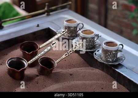 (251113) -- ANKARA, 13. November 2025 (Xinhua) -- dieses Foto vom 12. November 2025 zeigt, wie der türkische Kaffee mit heißem Sand in Ankara, T¨¹rkiye, aufgebrüht wird. Beim Brühvorgang von türkischem Sandkaffee werden kleine Kaffeekannen in einem Bett aus heißem Sand gebrüht. (Mustafa Kaya/Handout Via Xinhua) Stockfoto