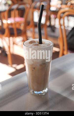 Kalter Kaffee, serviert in einem hohen Glas an einem sonnigen Tag Stockfoto