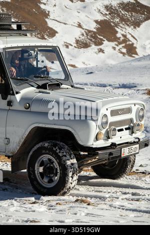 Naryn, Kirgisistan - 12. November 2025: Nahaufnahme eines weißen UAZ Patriot Offroad-Fahrzeugs mit einem erwachsenen Fahrer im Inneren, auf einem geparkt Stockfoto
