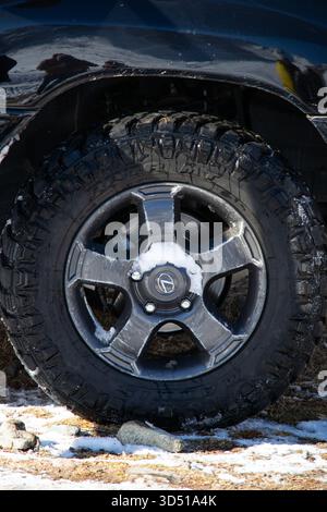 Naryn, Kirgisistan – 12. November 2025: Ein Nahaufnahme des Rades und Geländebereifens eines schwarzen Toyota Land Cruiser 100, mit Schnee auf dem Th Stockfoto