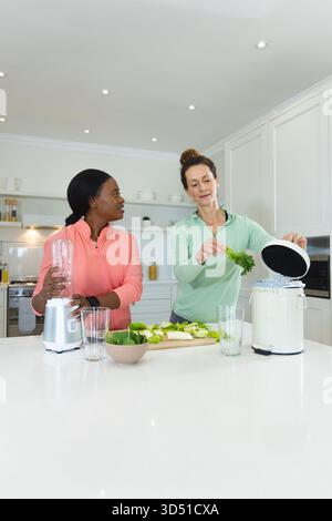 Zubereitung verschiedener Freundinnen mit Mixer und Kompostierung auf Kücheninsel, mit Kompostierbehälter Stockfoto