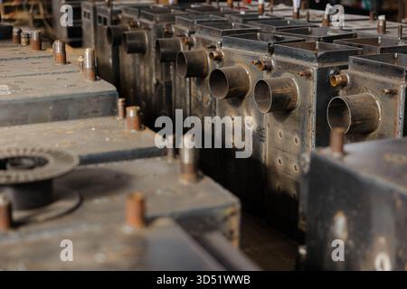 Metallteile und Kesselkomponenten sind in einer lebendigen Werkstatt übersichtlich angeordnet und zeigen den komplizierten Fertigungsprozess. Stockfoto