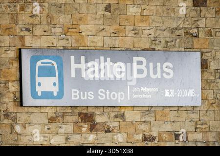 Bushaltestelle Schild mit Informationen zu den Servicezeiten am Flughafen auf Indonesisch Stockfoto