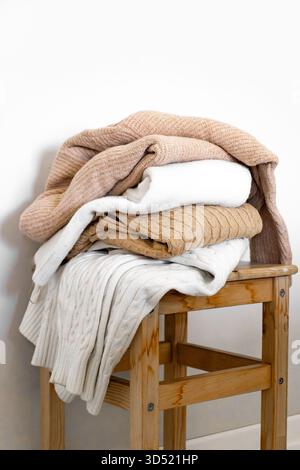 Nahaufnahme warmer Strickpullover in Pastellfarben und Beige, ordentlich gestapelt. Stockfoto