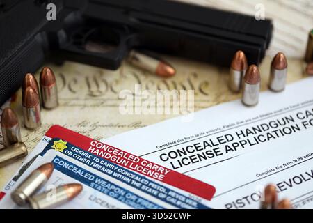 US-Schusswaffenlizenz und Pistole mit Kugeln auf US-Verfassung. Waffenerlaubnis und Verfassung - zweites Zusatzkonzept Stockfoto