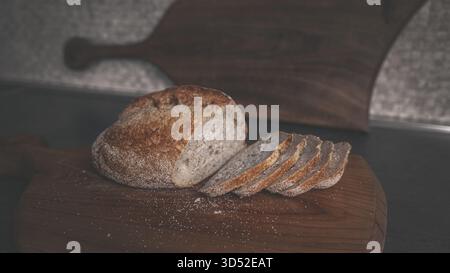 Geschnittenes Buchweizenbrot auf einem Holzbrett, minimales rustikales Lebensmittel Stillleben geeignet für Bäckerei und gesunde Esskonzepte Stockfoto