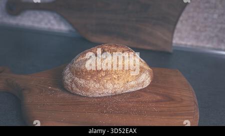 Frische Scheiben von dunklem Buchweizenbrot auf einem Holzbrett, einfache Überkopfkomposition für Bäcker und kulinarische Themen Stockfoto