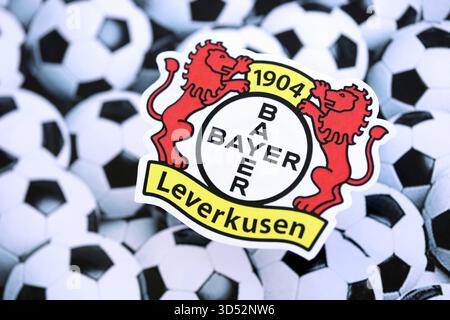 KIEW, UKRAINE - 23. FEBRUAR 2025 Bayer 04 Leverkusen Fußballklub-Abzeichen liegt auf der Fussball-Hintergrundbanner Stockfoto