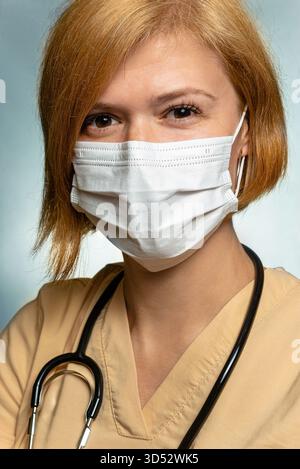 Ärztin, Angestellte im Gesundheitswesen. Ein vertikales Nahporträt, das ihren gesamten Kopf und ihre Schultern zeigt. Ein Stethoskop ist um ihren Hals. Sie ist müde Stockfoto
