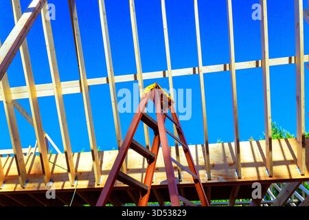 Die Arbeiter bauen Holzrahmen für Häuser mit Hilfe von Leiterwerkzeugen unter Balken Dachbalken Stockfoto