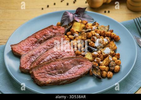 Mittelseltenes Steak mit Kräuterkartoffeln und Kichererbsen Stockfoto