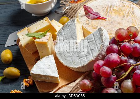 Köstliche Käseplatte mit Trauben und Oliven für einen perfekten Snack Stockfoto