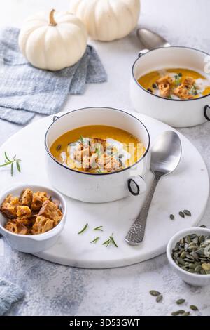 Kürbissuppe mit hausgemachten frischen Sauerteigcroutons, bequemes Herbstdinner mit ausgewogenen Speisen Stockfoto