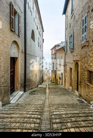 Malerische Straße in Fermos Altstadt mit Steintreppen, rustikalen Gebäuden und zeitlosem italienischem Charme, ideal für Reisen, Architektur und Stockfoto