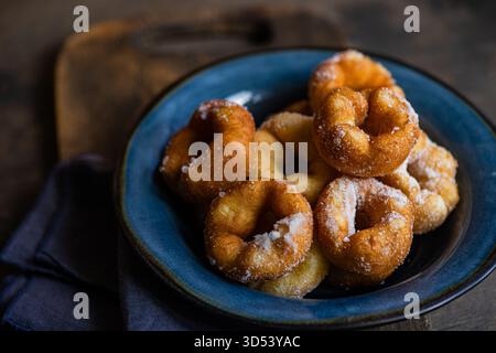 Nahaufnahme einer Schüssel hausgemachter Donuts, mit Puderzucker bestäubt Stockfoto