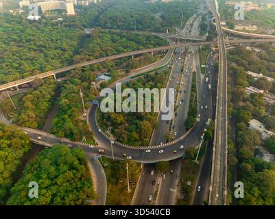 Aus der Vogelperspektive auf die komplexe Autobahnkreuzung inmitten eines Meeres von grünen Bäumen, die die Infrastruktur der Stadt zeigt, Neu-Delhi, Delhi, Indien. Stockfoto