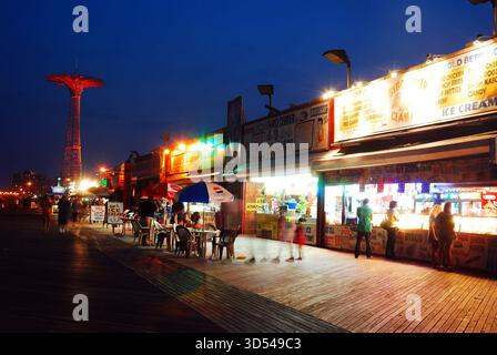 Coney Island, NY, USA 10. Juni 2011 die Promenade in Coney Island New York wird an einem warmen Sommernacht erleuchtet, während die Leute ihr spätes Abendessen genießen Stockfoto