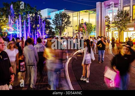 Shopper im Grove at Farmers Market in Los Angeles, Kalifornien, spazieren Sie nachts durch das Einkaufszentrum, vorbei am Brunnen, lange Zeit Stockfoto