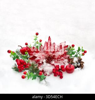 Weihnachtsdekoration. Blume aus rotem Weihnachtsstern, Zweige, Tannenzapfen und roten Beeren bedeckt Schnee auf Schnee mit Platz für Text Stockfoto