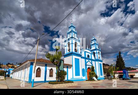 Immaculate Conception Church in Concepcion, Junin, Peru. Das weiß-blaue Gebäude im Kolonialstil steht unter einem dramatischen bewölkten Himmel Stockfoto