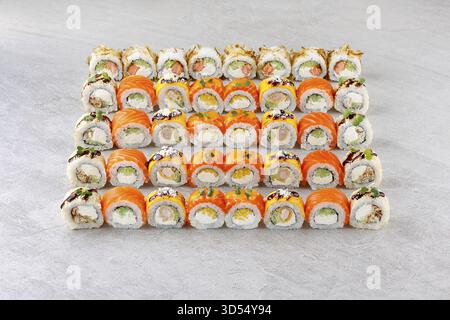Essen, japanische Sushi-Brötchen, Sushi-Sets auf grauem Hintergrund für Restaurantmenü und Essenslieferung Stockfoto