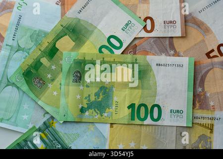 Auf der Oberfläche sind verschiedene Euro-Banknoten verteilt, die unterschiedliche Stückelungen mit Sternen der Europäischen Union und Sicherheitsmerkmalen aufweisen. Konzept der europäischen Währung Stockfoto