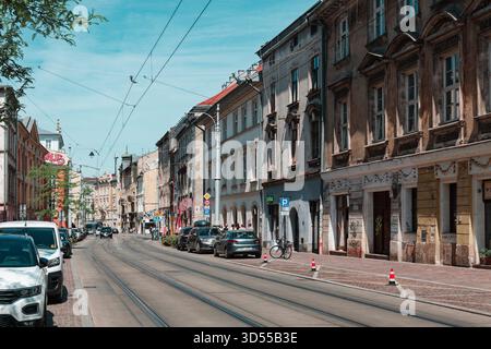 Historische Straße mit Straßenbahnschienen, alten Gebäuden und geparkten Autos. Stockfoto