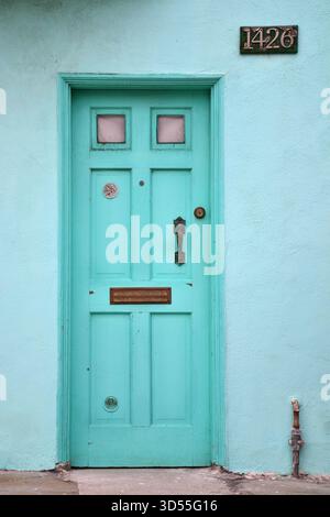 Mintgrüne Eingangstür mit pinkfarbenen Fensterpaneelen und Hausnummer 1426 in San Francisco mit klaren Linien und einer sanften Pastellfarbe Stockfoto