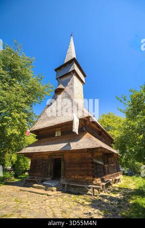 Die Kirche St. Parascheva, ein historisches Holzdenkmal aus den 1700er Jahren, steht auf einem traditionellen Friedhof in der Region Maramures in Rumänien Stockfoto