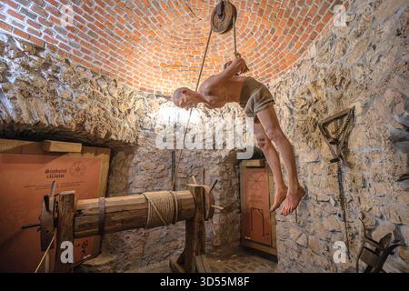 Transsilvanien, Rumänien - 8. Oktober 2025: Schaufensterpuppe mit Körper, der von Flaschenzug gehängt wird und historische Folterpraktiken in einer Museumsausstellung zeigt Stockfoto