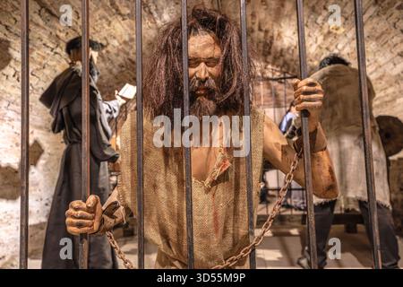 Transsilvanien, Rumänien - 8. Oktober 2025: Gefangenenpuppe in einem Käfig im Folterkammermuseum auf Schloss Corvin, Hunedoara, Rumänien. Repräsentieren Stockfoto