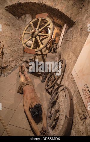 Transsilvanien, Rumänien - 8. Oktober 2025: Schaufensterpuppe in einem historischen Kostüm mit einem Brechen-Rad im Museum der Folterkammer in der Burg Corvin Stockfoto
