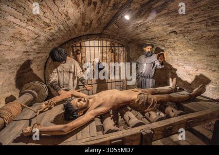 Transsilvanien, Rumänien - 8. Oktober 2025: Schaufensterpuppen, die einen Gefangenen auf einem Regal und einen Henker im Folterkammermuseum auf der Burg Corvin darstellen Stockfoto