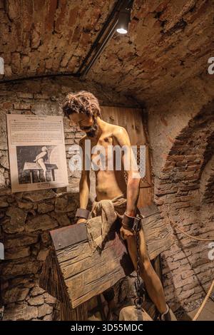 Transsilvanien, Rumänien - 8. Oktober 2025: Schaufensterpuppe, die einen Gefangenen in mittelalterlichen Beständen darstellt, mit schweren Gewichten in der Corvin Castle Folter angekettet Stockfoto
