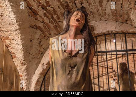 Transsilvanien, Rumänien - 8. Oktober 2025: Schaufensterpuppe, die ein Opfer darstellt, das an heißen Kohlen leidet, in einer historischen Folterkammer, Corvin Castle Stockfoto
