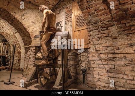 Transsilvanien, Rumänien - 8. Oktober 2025: Schaufensterpuppe, die ein Opfer darstellt, das ein öffentliches Foltergerät erträgt und historische Brutalität in einem Mittelalter zeigt Stockfoto