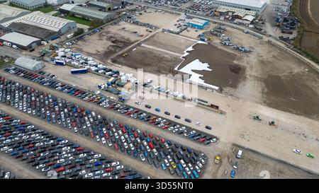 Aus der Vogelperspektive auf einen großen Autolager- und Industriebereich mit zahlreichen geparkten Fahrzeugen und einigen Baumaschinen auf Copart Yard, York Stockfoto