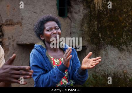 Gasura Ruanda - 8. September 2025; authentische schwarze afrikanische Frau mittleren Alters, die mit einem kleinen Lächeln die Hände klatscht. Stockfoto