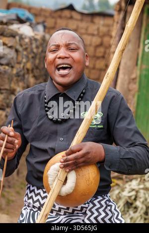 Gasura Ruanda - 8. September 2025; authentische Schwarzafrikaner, die sich im Dorfleben und Tourismus engagieren, spielen fröhlich und lachend Instrument. Stockfoto