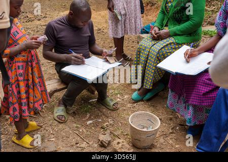 Gasura Ruanda - 8. September 2025; afrikanische Dorfbewohner auf der Straße, die ihre Einnahmen zusammenfassen und ihr Geld abrechnen. Stockfoto