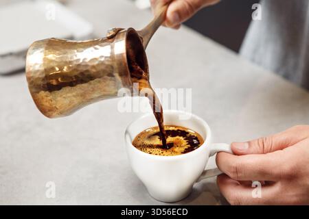 Traditioneller Türkischer Kaffee Wird Aus Kupfer Cezve In Den White Cup Gegossen Stockfoto