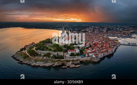 Rovinj, Kroatien - Panoramablick auf die Altstadt von Rovinj mit Kirche St. Euphemia und dramatischem goldenem und blauem Sonnenaufgang an einem Sommermorgen Stockfoto