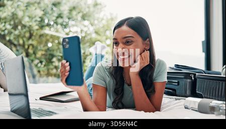 Glückliche Frau, Reise oder Koffer mit Selfie auf dem Bett für Fotos, Bilder oder Erinnerungen im Hotel. Entspannen Sie sich, weibliche Person oder lächeln Sie mit Momenten für Stockfoto