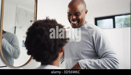 Unterrichten, Zähneputzen und Vater mit Kind im Badezimmer zu Hause für Zahnpflege, Hygiene oder Wellness. Lernen, Mundgesundheit und afrikanischer Vater mit Stockfoto
