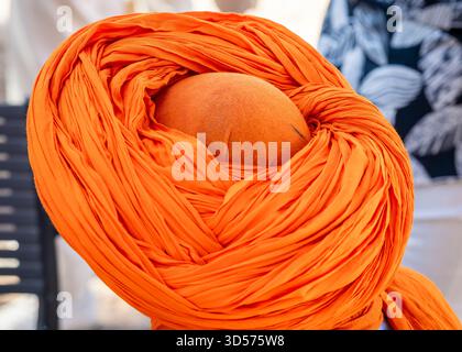 Berber kleidete einen traditionellen Turban, Ouarzazate, Marokko. Marokkanischer Mann mit orangefarbenem Turban, Blick von oben. Stockfoto