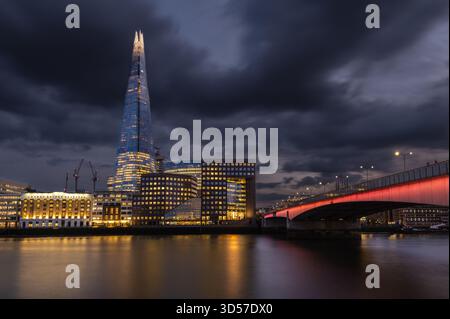 Langzeitbelichtung Nachtsicht des Shard über die Themse mit Blick auf die London Bridge. Wunderschöne Beleuchtung und dramatischer Himmel. Stockfoto
